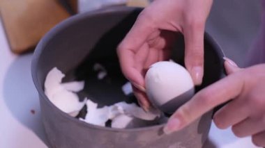 Kadınların elleri, mutfakta yumurta kabuklarıyla dolu bir tencerede kaynamış beyaz bir yumurtayı dikkatlice soyuyordu.