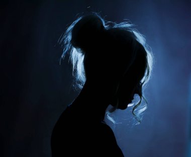 Yumuşak arka planda bir kadının sanatsal silueti. Yumuşak kontrastlı ve karamsar atmosferli minimalist portre konsepti.