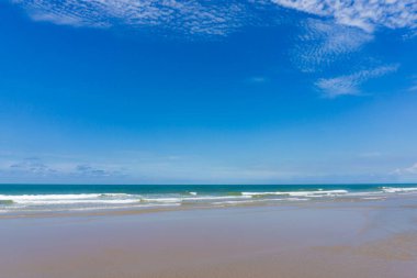 Güzel, pürüzsüz, uzun ve kumlu bir sahil. Boş deniz mavi ufukla buluşuyor, ince bulutlar. Hafta sonları ve yaz tatillerinde rahatlatıcı atmosfer.
