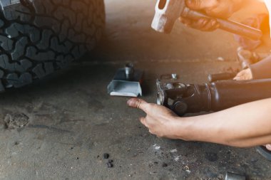 Tamirci, arka evrensel eklem montaj iğnesine vurmak ve bastırmak için çelik bir çekiç kullanıyor. Bu DIY yöntemi çoğu araba, oto tamirhanesi ve hizmet merkezleri için uygundur..