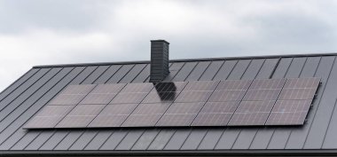 Özel bir konutun çatısına güneş panelleri yerleştirilmiş. Görüntü, iç ortamdaki yenilenebilir enerji teknolojisini gösteriyor..