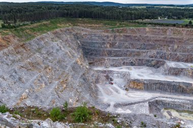 Yüksek açılı çekim, Kamieniolom Ostrowka taş ocağının dik kuzey yüzünü ve bitişik Todowa Grzaba tepesini gösteriyor. Devonian-Karbonifer sınır tabakasını ortaya çıkarıyor.