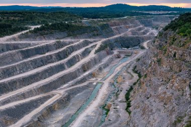 Yüksek açılı çekim, Kamieniolom Ostrowka taş ocağının dik kuzey yüzünü ve bitişik Todowa Grzaba tepesini gösteriyor. Devonian-Karbonifer sınır tabakasını ortaya çıkarıyor.