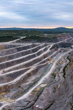 Yüksek açılı çekim, Kamieniolom Ostrowka taş ocağının dik kuzey yüzünü ve bitişik Todowa Grzaba tepesini gösteriyor. Devonian-Karbonifer sınır tabakasını ortaya çıkarıyor.