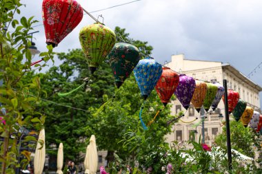 Renkli Çin tarzı kağıt fenerler şenlikli süslemeler olarak asılı, içeride ve dışarıda rahat ve geleneksel bir atmosfer yaratıyor..
