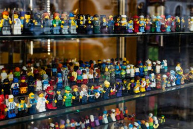 Bir mağazanın vitrininde duran büyük bir LEGO minyatür koleksiyonu, popüler oyuncak serisinden çeşitli karakterleri ve temaları gösteriyor. Sadece editör kullanımı.