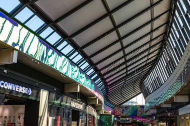 Lodz, Polonya 'daki Manufaktura alışveriş merkezinin geniş iç mekanında modern mimari, yüksek tavanlar ve şık tasarım detayları sergileniyor..