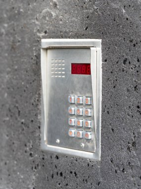 Bir apartmanın duvarına monte edilmiş modern bir dahili iletişim sisteminin yakın görüntüsü..