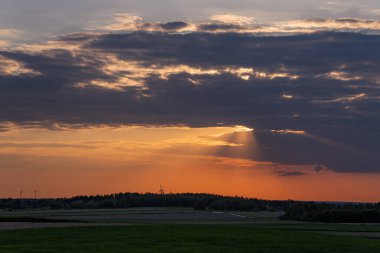 Güzel bir gün batımı, açık bir arazide sıcak altın renkleri ile sakin ve huzurlu bir atmosfer yaratır..