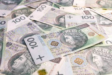 Polonya parasından oluşan kaotik bir arka plan, sadece 100 zloti banknotla dinamik bir finansal doku oluşturmak için rastgele düzenlenmiş..