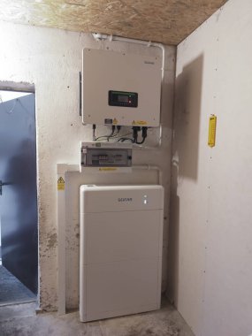 Elektrik paneli ve pil depolama sistemiyle donatılmış duvar çeviricisi, güç dönüşümü ve depolama için modern enerji yönetim ekipmanlarını gösteriyor.