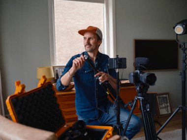 Mobil çekim hazırlıkları sırasında akıllı telefon sabitleyici kontrollerini tam olarak yapılandıran kameraman