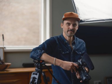 Teçhizat tanıtım oturumu sırasında kamerayı animasyon ifadesiyle tutkulu bir kameraman tutuyor.