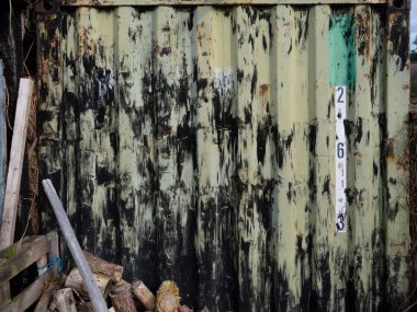 Görünür sayılar ve damlayan boya dokusuyla yıpranmış ahşap. Yaşını ve bozulmasını gösteriyor.