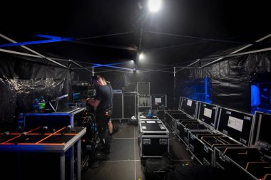 Çadır alanı altında uçuş davaları arasında çalışan teknisyenle birlikte profesyonel sahne arkası kurulumu