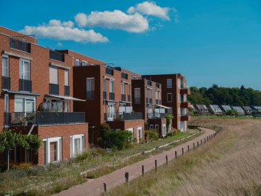 Vatandaşlık edinilmiş çayırlı ve uzak ormanlı modern tuğlalı binalar.