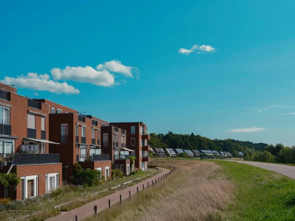 Çağdaş tuğlalı daireler, yaya yolu ile vatandaşlık verilmiş hendek manzarası.