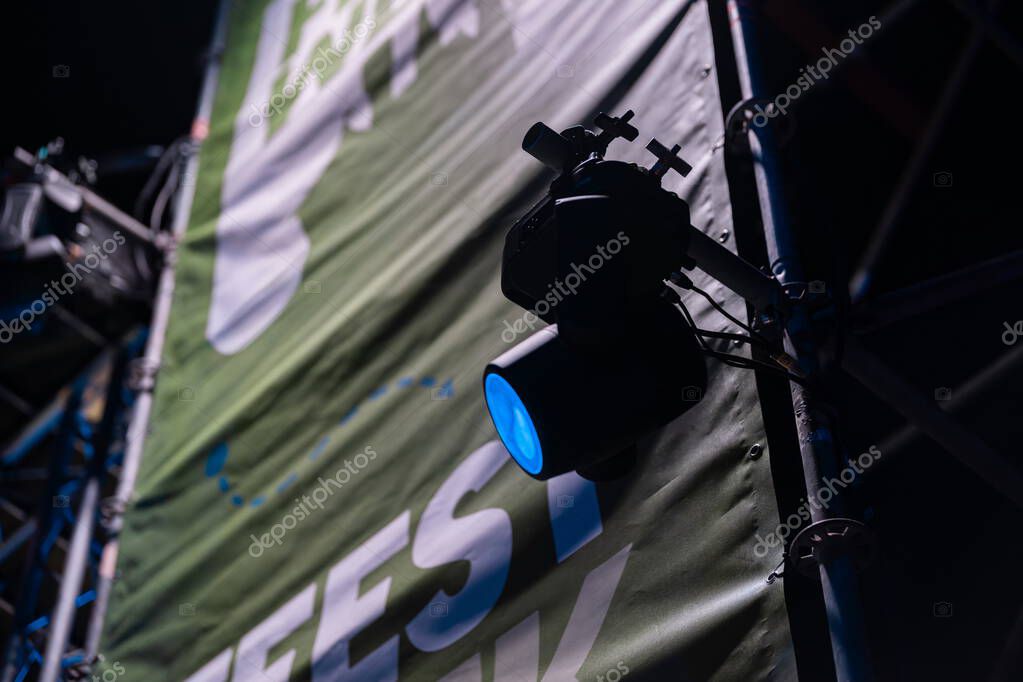 Professional stage light fixture with blue color filter mounted on stand with event branding