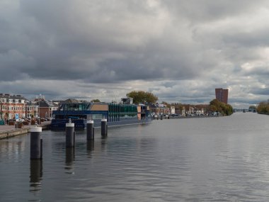 Limanda demirli modern rıhtım binaları ve bulutlu gökyüzü altın saatinde.