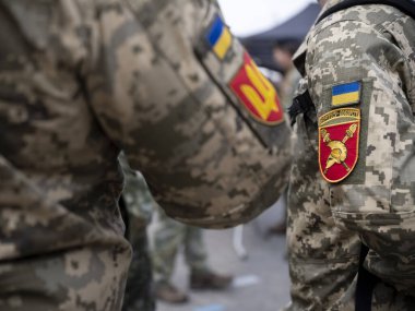 Ukrayna silahlı kuvvetlerinin ayrıntıları, dijital kamuflaj üzerine ulusal bayrak ve topçu birliği amblemli yamalar