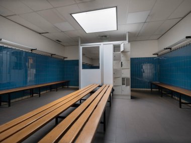 Merkezi beyaz dolaplı ve mavi fayanslı spor salonu soyunma odasının simetrik görüntüsü