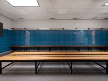 Spor tesisi soyunma odasındaki ahşap bankların düşük açılı görüntüsü mavi fayanslı ve perde arkası
