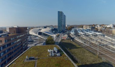 Arnhem 'deki demiryolu raylarına tepeden bakan kavisli mimarisi ve yüksek kulesi olan modern tren istasyonunun hava perspektifi (bu görüntü anamorfik mercekle yapılmıştır)