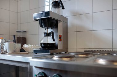 Günümüz mutfağında şeffaf sürahi demleyen profesyonel kahve makinesi.