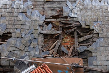 Kırık döşemeleri ve bozulmuş iskeleti gösteren ağır hasarlı çatıyı yakın görünüm