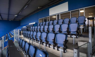 Arka sıralarda VIP locaları olan mavi plastik stadyum koltukları. Anamorfik mercekle çekilmiş..