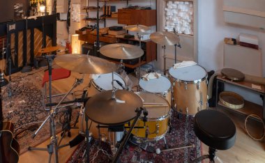 Ziller ve klasik ses ekipmanlarıyla kayıt stüdyosunda profesyonel bateri seti. Anamorfik mercekle çekilmiş..