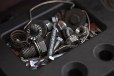Çeşit çeşit metal cıvatalar fındık vidaları yaylar ve bağlayıcılar siyah plastik alet kutusunda düzenlenmiş