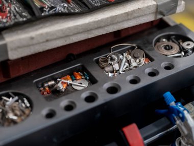 Bölünmüş depolama bölümünde sigorta yayları ve küçük otomotiv parçaları içeren araç düzenleyici tepsisi