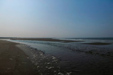 Gelgit havuzları ve alçak gelgitte kumlu plajları olan geniş kıyı manzarası