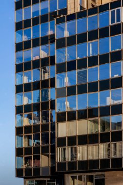 Çağdaş ofis binasının dış tarafında yansıtıcı mavi cam pencereler var.