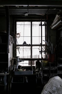 Siluetli araçlar ve endüstriyel çalışma alanı atmosferiyle arka ışıklandırma atölyesi penceresi