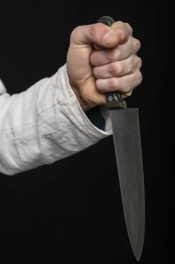 Profesyonel şef bıçağı sapını sıkıca kavrayan dramatik bir yakın çekim.
