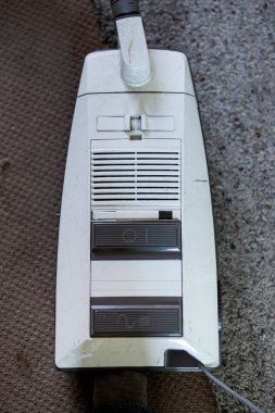 Beton yüzeyde eskimiş beyaz elektrikli süpürge retro tasarım ve aşınmayı gösteriyor. Geçmiş yıllardan kalma nostaljik ev aletleri..