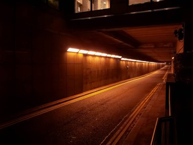 Ilık turuncu ışıklandırmalı aydınlatma ve şehir altyapısını gösteren trafik ışıklarının geçtiği aydınlatma tüneli.
