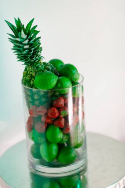 Cam vazoda yeşil ananas, limon ve çilek, kavramsal yemek fotoğrafçılığı ve renk temalı tasarım ile yaratıcı bir hayat..