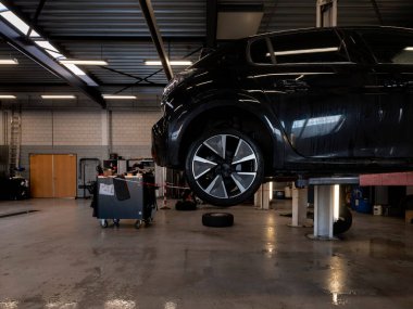 Çeşitli araç gereç ve gereçlere sahip otomobil atölyesi çalışma alanı, fayanslı duvar arka planı, otantik çalışma ortamı