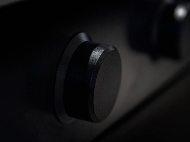 Çelik mutfak yüzeyi üzerindeki siyah mat kontrol düğmesi indüksiyon ocağı veya fırın için