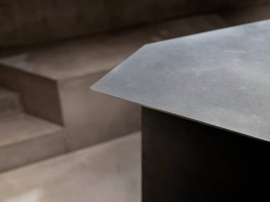 Paslanmaz çelik tezgahın minimalist yakın planı bulanık beton arka plana karşı