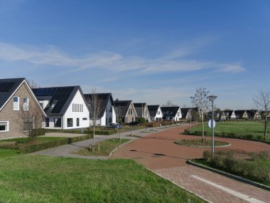 Yeni geliştirme alanında güneş paneli evleri ve kırmızı tuğlalı bisiklet yolu olan Hollanda yerleşim yeri