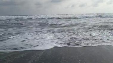 Büyük dalgalar siyah kumsalda