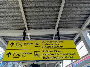 Sarı yönlü işaret, geçiş kullanıcıları veya turizmle ilgili bağlamlar için açık kentsel rehberlik sağlayan yol bulma talimatları içeren çıkış yollarını gösterir.