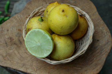 Bir sürü sarı limon dokuma sepetinde oturur. İçindeki sulu suyu gösterir. Sağlıklı beslenme ve taze malzemeler için harikadır..
