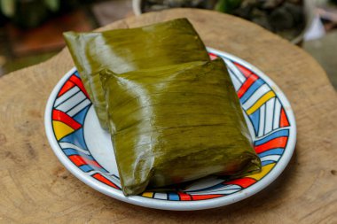 İki yeşil ambalajlı yiyecek, açık havada renkli bir tabakta oturur. İştah açıcı bir natürmort sunar. Mutfak geleneklerini sergilemek için birebir..
