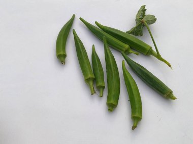 Sade beyaz bir yüzeye yapraklı taze yeşil bamya sağlıklı ve besleyici bir sebze bileşeni olarak kullanılabilir..