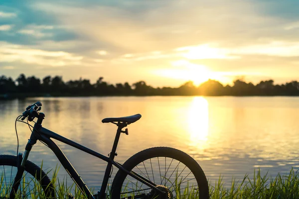 Silhueta Montanha bicicleta por do sol no rio — Fotografia de Stock